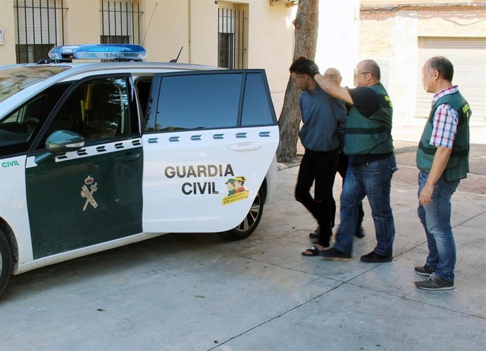 Uno de los detenidos por el asalto, custodiado por la Guardia Civil