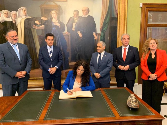La consejera de Igualdad, Rocío Ruiz, firma este lunes en el libro de honor del Ayuntamiento de Granada, en presencia del alcalde, Luis Salvador.