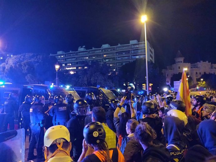 Manifestantes tiran algunos objetos contra el cordón policial en la Diagonal frente al Palau de Congressos de Catalunya donde está la Familia Real