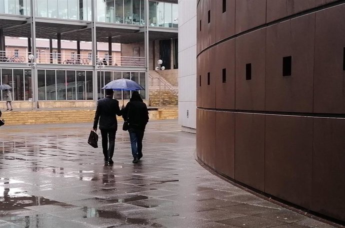 El condenado abandona el juzgado totalmente cubierto y en compañía de su abogado.