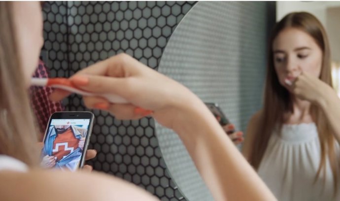 Una joven consulta la app de Cruz Roja de Voluntariado mientras se cepilla los dientes