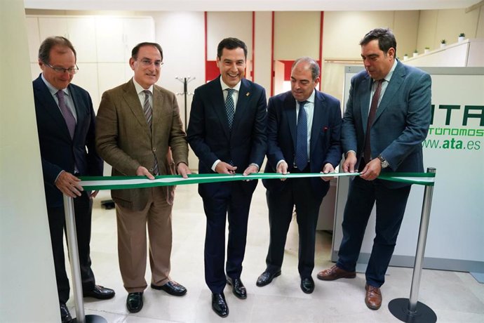 El presidente de la Junta, Juanma Moreno (c) asiste a la inauguración de la nueva sede de ATA en Andalucía junto al presidente nacional de ATA, Lorenzo Amor (2d). Foto de archivo.