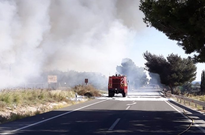 Un camión de bomberos junto al vertedero incendiado cerca del aeropuerto.