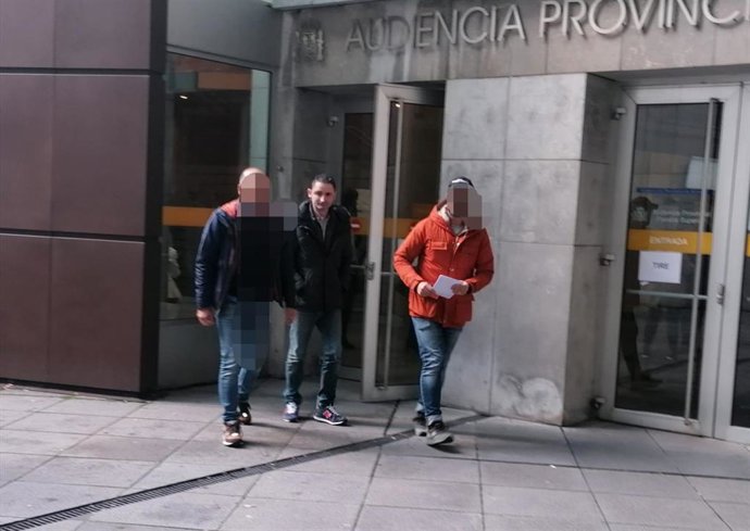 El p`rocesado abandona la Audiencia flanqueado por dos agentes de la Policía.