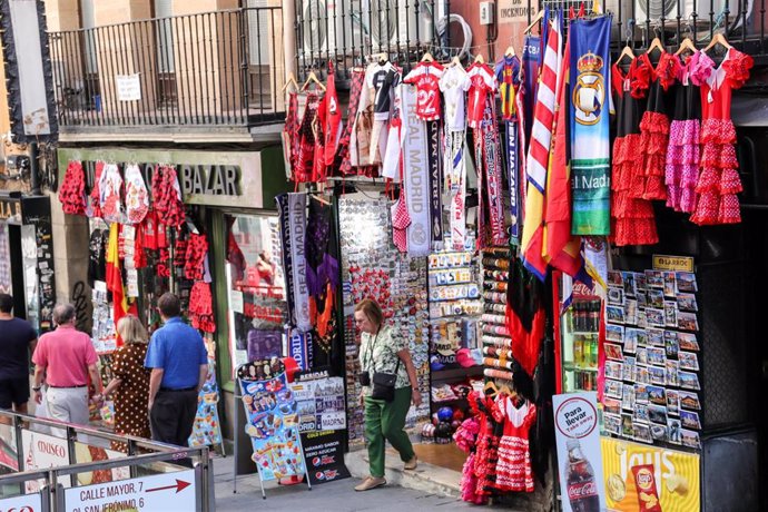 Varios turistas realizan compras en una de las tiendas ubicada en una calle cercana a la Plaza Mayor de Madrid.