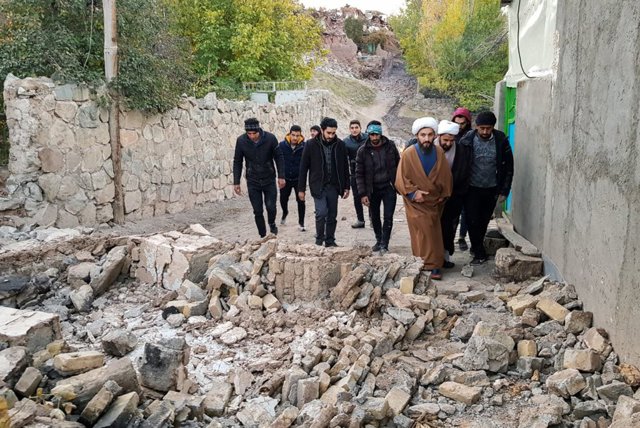Hombres caminan sobre los destrozos materiales tras el terremoto  registrado en el noroeste de Irán