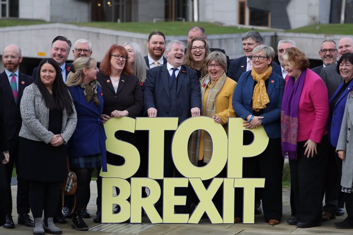 08 de Novembre del 2019, Edimburg: Cap de SNP a la Cambra dels Comuns Ian Blackford (C), posen per una fotografia amb el cartell de "Stop Brexit".