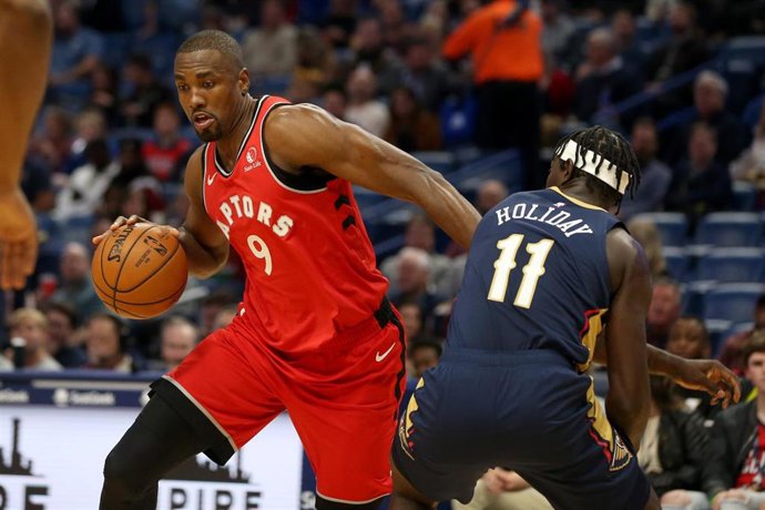 Serge Ibaka, de Toronto Raptors, ante Jrue Holiday, de New Orleans Pelicans