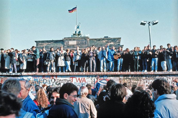 Los ciudadanos de la la República Federal de Alemania (RFA) y la República Democrática Alemana (RDA) celebran la caída del muro de Berlín frente a la Puerta de Brandeburgo, en Berlín (Alemania), a 9 de noviembre de 1989.