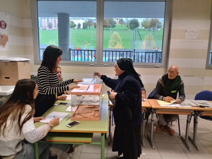 Una monja deposita su voto en el colegio electoral