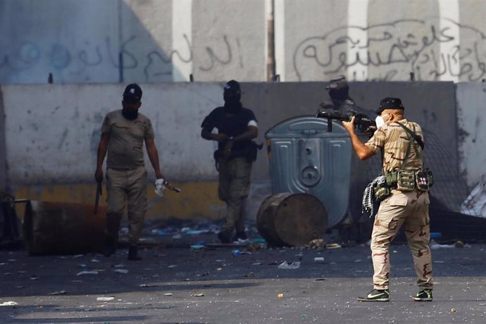 Unm miembro de las fuerzas de seguridad apunta a los manifestantes en Bagdad