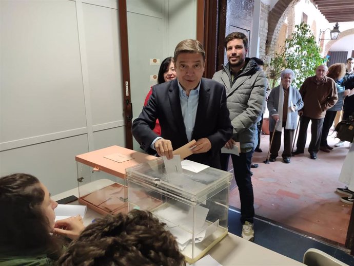 Luis Planas vota en Córdoba acompañado por uno de sus hijos.