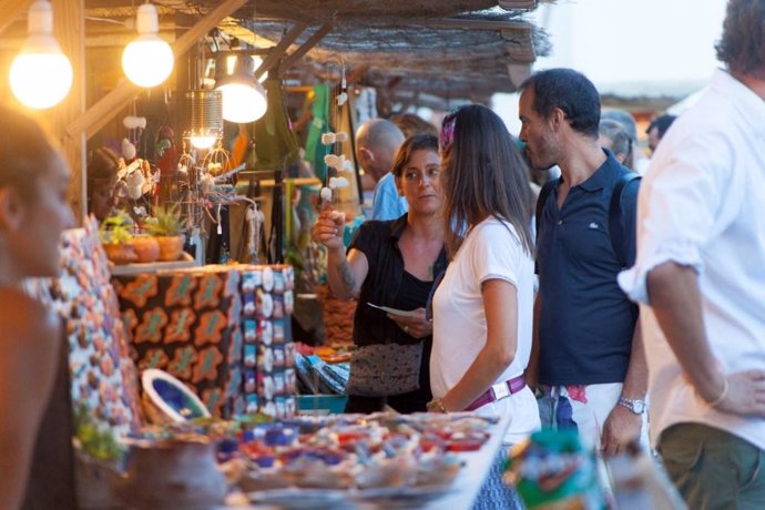 Turistas en un mercado artesano en Formentera, comercio minorista, turismo, venta