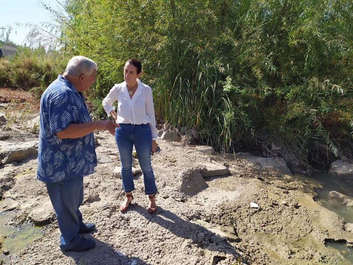La portavoz municipal de Vox, Paula Badanelli, en una visita al río junto a un vecino.