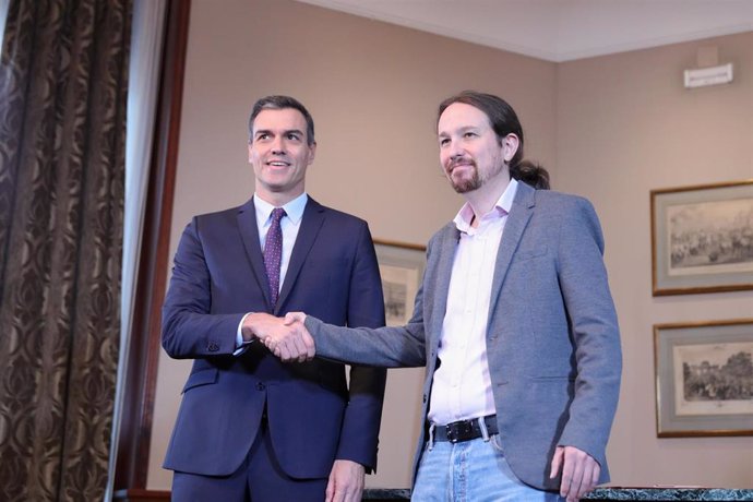 El presidente del Gobierno en funciones, Pedro Sánchez y el líder de Podemos, Pablo Iglesias, se estrechan la mano en el Congreso de los Diputados tras firmar el principio de acuerdo para compartir un gobierno de coalición tras las elecciones generales.