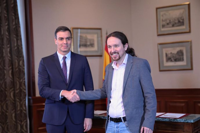 El president del Govern en funcions, Pedro Sánchez i el líder de Podem, Pablo Iglesias, s'encaixen la m al Congrés dels Diputats després de signar el principi d'acord per compartir un govern de coalició després de les eleccions generals.