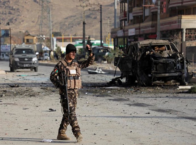 A member of the Afghan security forces keeps watch at the site of a suicide blas