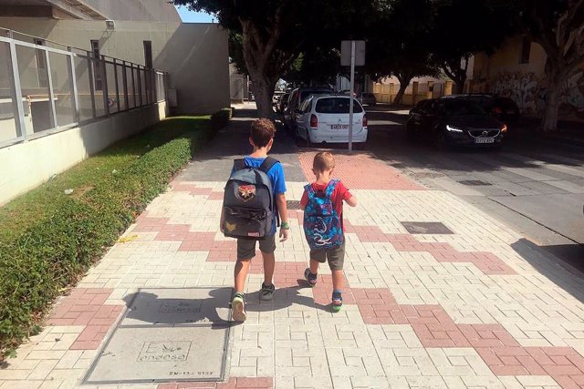 Niños caminando con una mochila
