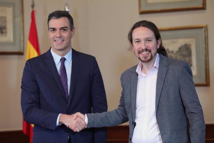 El presidente del Gobierno en funciones, Pedro Sánchez y el líder de Podemos, Pablo Iglesias, se estrechan la mano en el Congreso de los Diputados tras firmar el principio de acuerdo para compartir un gobierno de coalición tras las elecciones generales 