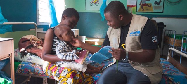 Una Madre Sostiene A Su Hijo De 18 Meses Mientras Lo Atienden En Un Hospital Del Distrito De Balaka En Malawi.