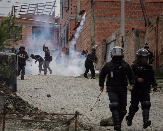 11 November 2019, Bolivia, La Paz: Policemen run away as supporters of Evo Morales throw stones at them. Protests raged on Monday in La Paz amid uncertainty about who is in charge in Bolivia after President Evo Morales resigned. Photo: Gaston Brito/dpa