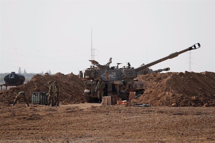 Soldados israelíes permanecen cerca de los proyectiles de artillería en una zona cercana a la Franja de Gaza