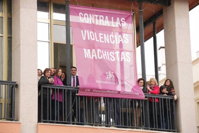 Izado de la bandera contra la violencia de género en el balcón del Ayuntamiento de Córdoba.