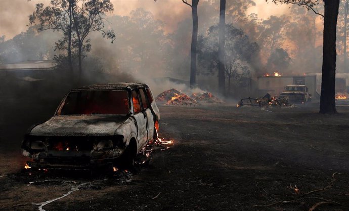Un coche quemado en el patio de una casa en el sur de Taree en Nueva Gales del Sur