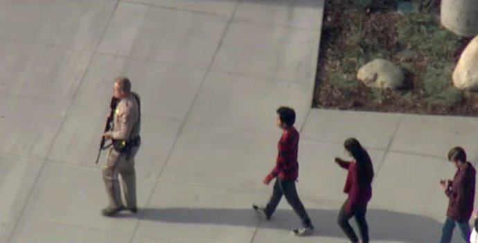 Un policía acompaña a estudiantes tras el tiroteo en el instituto Saugus de Santa Clarita, California.