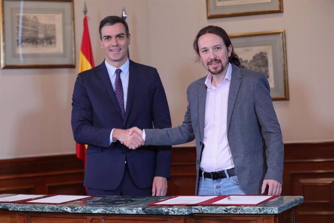 El presidente del Gobierno en funciones, Pedro Sánchez y el líder de Podemos, Pablo Iglesias, se estrechan la mano en el Congreso de los Diputados tras firmar el principio de acuerdo para compartir un gobierno de coalición tras las elecciones generales.