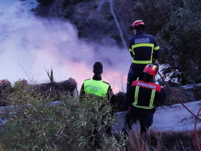Imagen de los bomberos de Almuñecar y la Policía Local tratando de sofocar el incendio declarado esta tarde