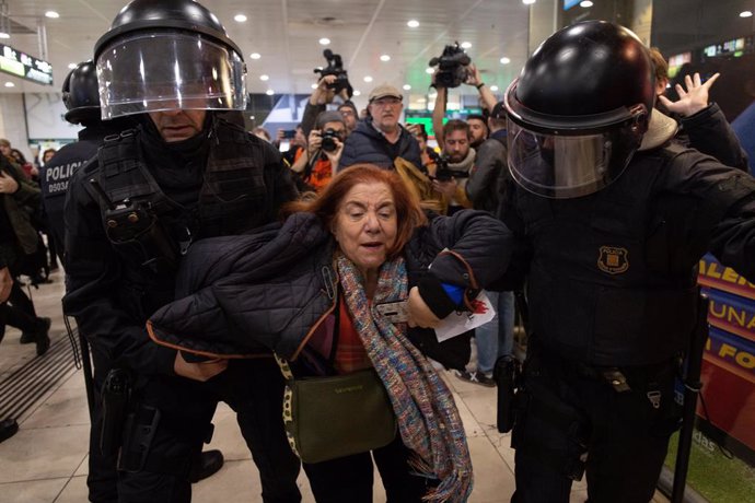 Els Mossos d'Esquadra treuen una a una les persones que participen en la seguda a l'estació de Barcelona Sants.