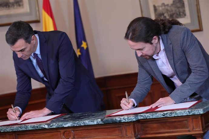 El presidente del Gobierno en funciones, Pedro Sánchez y el líder de Podemos, Pablo Iglesias, firmando en el Congreso el principio de acuerdo para compartir un gobierno de coalición.