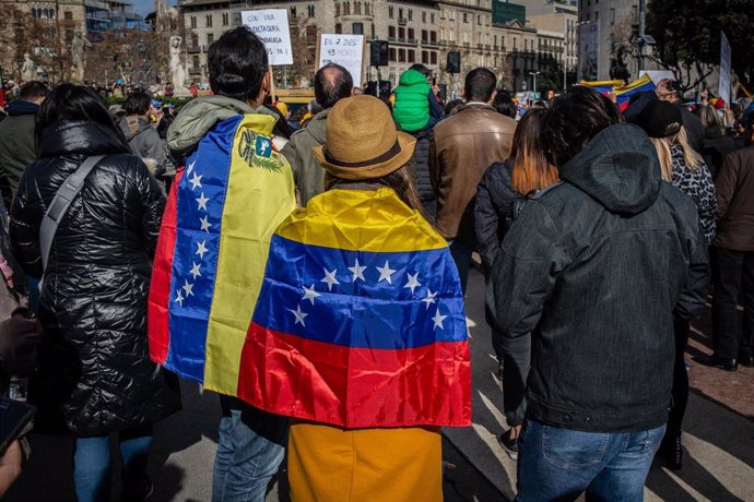 Participantes en la manifestación en Barcelona para respaldar el apoyo de la Unión Europea a Venezuela y el reconocimiento a Juan Guaidó como presidente interino visten banderas venezolanas.  