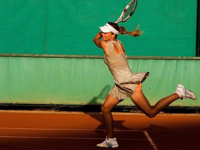 Mujer jugando al tenis.