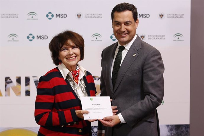 Juanma Moreno entrega un premio por la creación de la Fundación Medina a Regina Revilla
