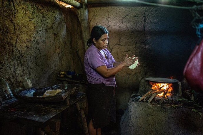 Una mujer guatemalteca cocina maíz