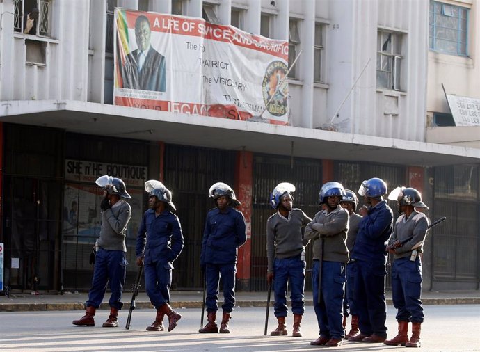 Policías delante de la sede del partido opositor MDC