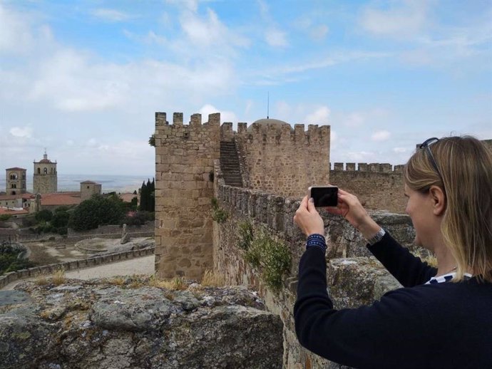 Una mujer hace una fotografía desde el castillo de Trujillo