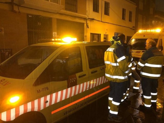 Efectivos del SUMMA 112 en las afueras del edificio del distrito de Carabanchel en el que un nieto ha degollado a su abuela.