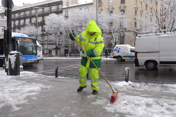 Un operario de limpieza del Ayuntamiento de Madrid retira nieve en la calle.