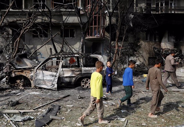 Niños pasan por el escenario de un atentado en Kabul