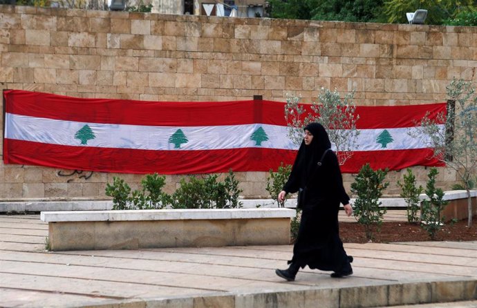 Una mujer delante de una bandera libanesa en Beirut
