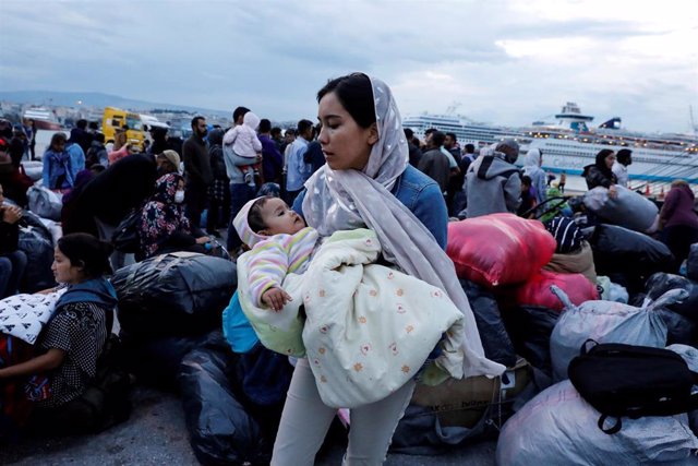 Una mujer sostiene a un bebe en el campamento de refugiados de la isla griega de Lesbos.