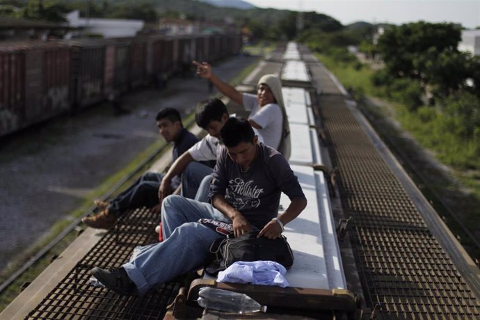 Un grupo de inmigrantes centroamericanos viajan subidos al techo de un tren que cruza la región fronteriza entre México y Estados Unidos de El Paso.