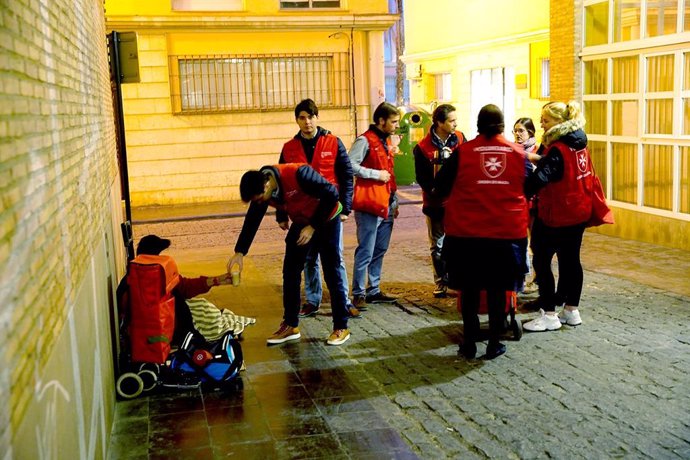 Voluntarios con una persona sin hogar en una imagen de archivo