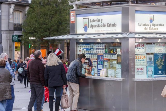 Varias personas esperan en cola para comprar un décimo de Lotería de Navidad en una Administración en la plaza de Puerta del Sol, en Madrid (España), a 18 de noviembre de 2019.