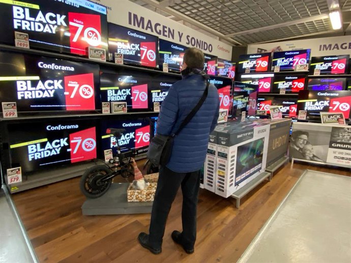 Interior de una tienda de Conforama en la que un hombre mira varias pantallas en las que se anuncian descuentos de hasta el 70% en el Black Friday del próximo 29 de noviembre, en Madrid a 19 de noviembre de 2019.
