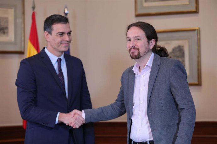 El presidente del Gobierno en funciones, Pedro Sánchez y el líder de Podemos, Pablo Iglesias, se estrechan la mano para compartir un gobierno de coalición tras las elecciones generales.