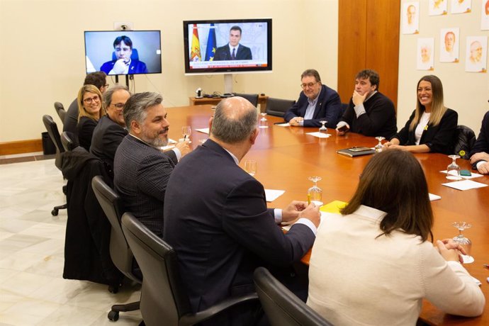Els portaveus de Junts per Catalunya en el Parlament, Albert Batet, Quim Torra, Elsa Atardi i Pere Aragons, entre altres portaveus del grup i del PDCat reunits (en pantalla amb Carles Puigdemont) veient la compareixena del president del Govern.